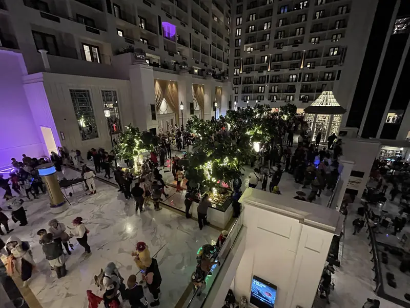 Attendees crowd the ballroom level at night.