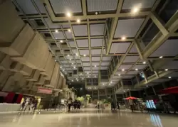 The main lobby features a monolithic concrete and steel structure with lots of greenery.