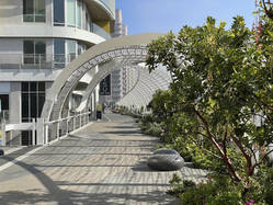 The Rainbow Bridge features a sweeping metal structure and modern landscaping.