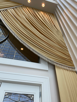 Rich gold curtains surround the doors to the ballroom.